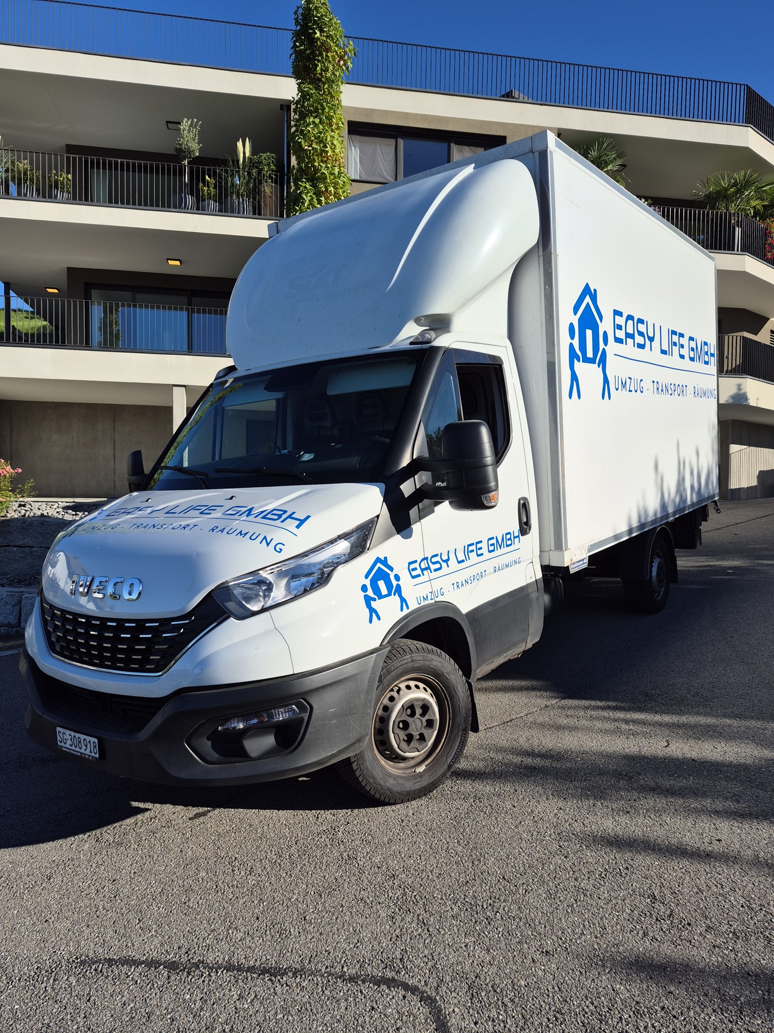 Easy Life Lieferwagen mit Firmenlogo vor einem Wohnhaus