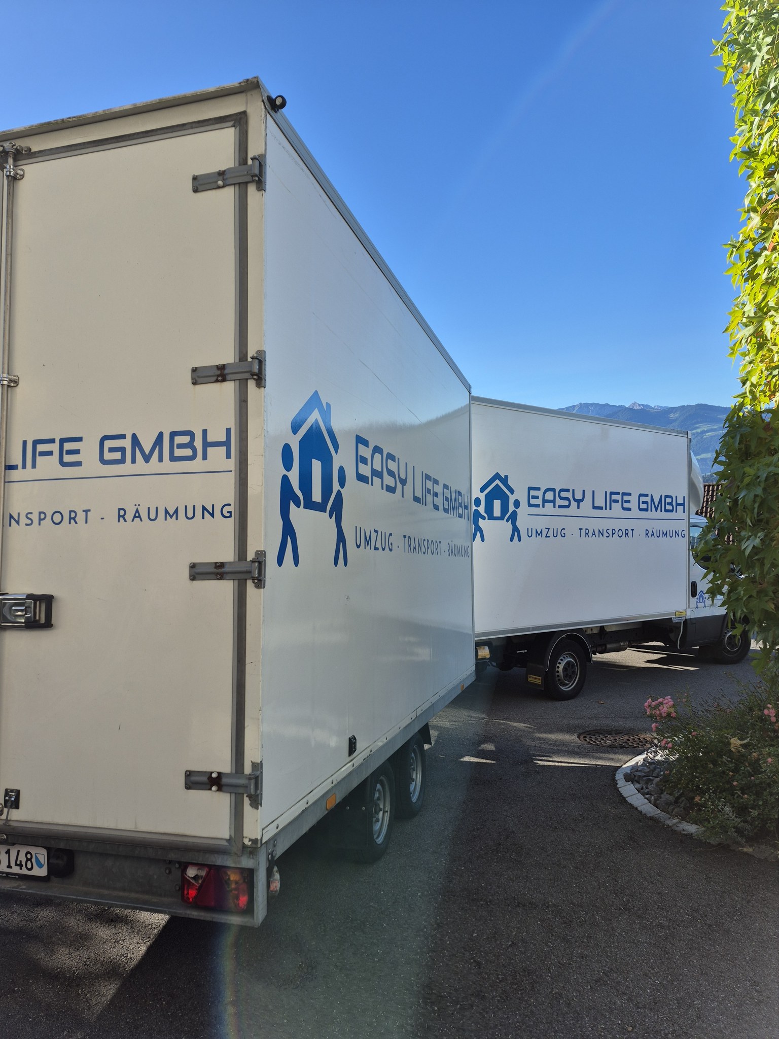 Easy Life Anhänger mit Firmenlogo vor einem Wohnhaus